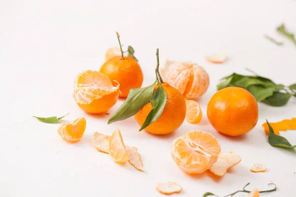 Mandarinas peladas y cáscara con hojas sobre fondo blanco — Foto de Stock