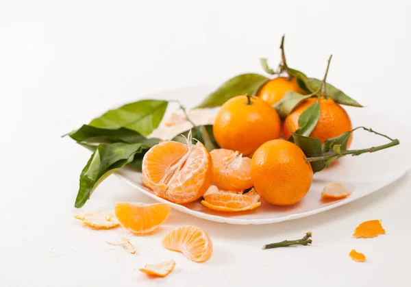 Mandarinas peladas y cáscara con hojas sobre fondo blanco — Foto de Stock