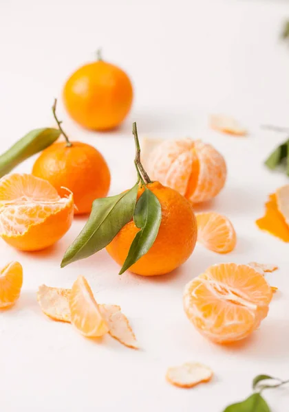 Mandarinas peladas y cáscara con hojas sobre fondo blanco — Foto de Stock
