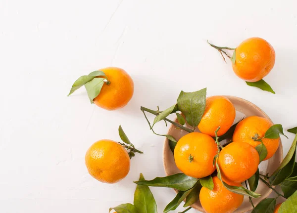 Mandarinas frescas con hojas verdes sobre un fondo blanco — Foto de Stock