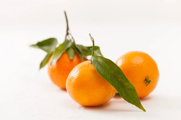 Mandarini freschi con foglie verdi su sfondo bianco — Foto Stock