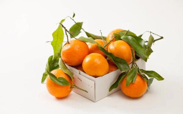 Свежие мандарины в коробке на белом фоне — стоковое фото