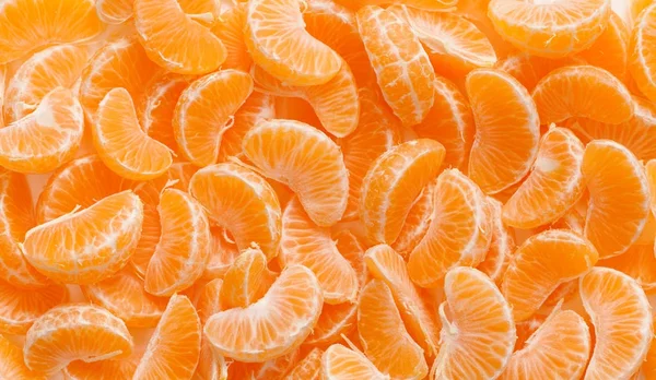 Фон из очищенных ломтиков мандаринских апельсинов — стоковое фото