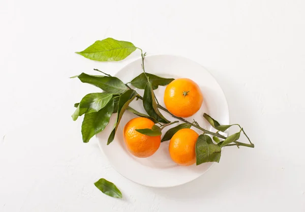 Свежие мандарины в миске на белом фоне — стоковое фото