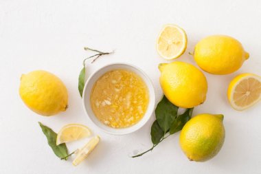 Taze limon ile yaprakları ve limon ve beyaz zemin üzerine bir kase şeker doğranmış.