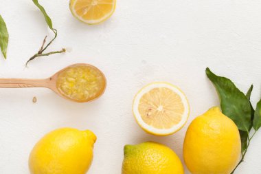 Taze limon ile yaprakları ve limon ve beyaz zemin üzerine bir kase şeker doğranmış.