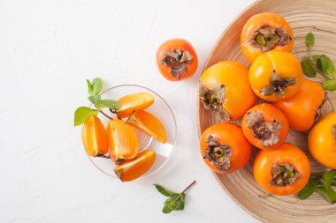 Kase beyaz masada kıyılmış olgun Trabzon hurması