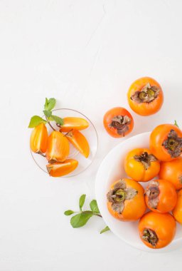 Kase beyaz masada kıyılmış olgun Trabzon hurması