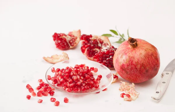 Granatäpple frukt med skalade granatäpple på en vit — Stockfoto