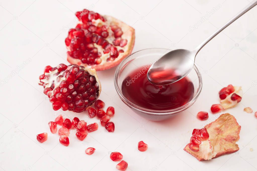 Jarabe de granada y granada quebrada sobre blanco 2022