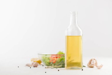 Baharat ve sebze salatası beyaz bir şişeyle yağda