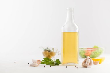 Baharat ve sebze salatası beyaz bir şişeyle yağda