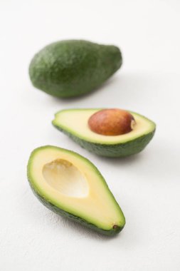 Beyaz bir tablo üzerinde olgunlaşmış dilimlenmiş avokado