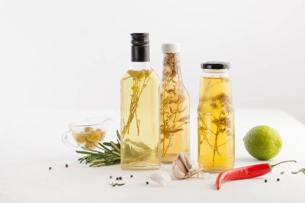 Масло с травами в бутылке салата на белом
