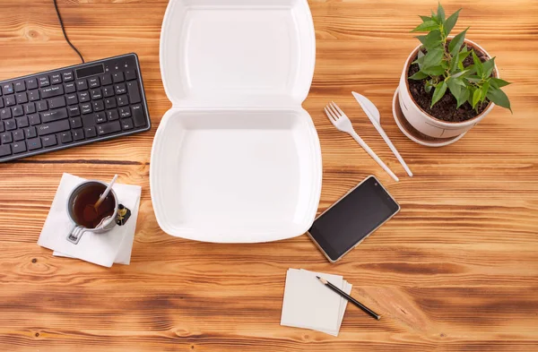 Container for food on a wooden table in the office — Stock Image Container for food on a wooden table in the office Stock Photo