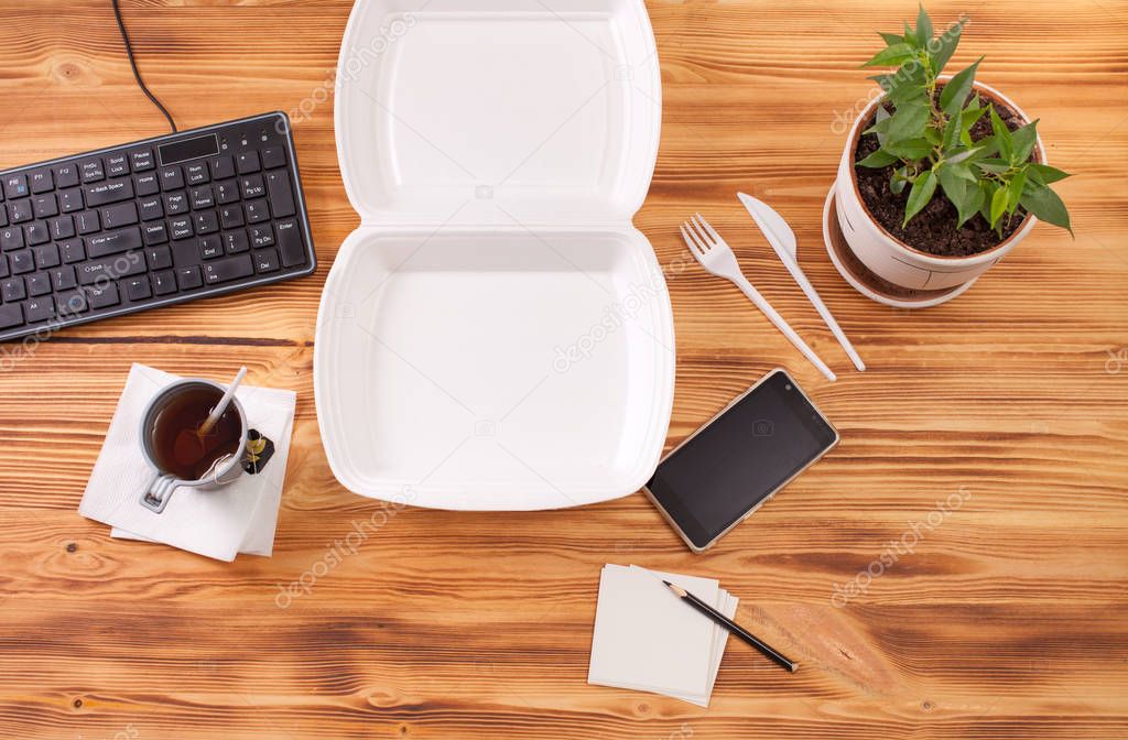 Container for food on a wooden table in the office