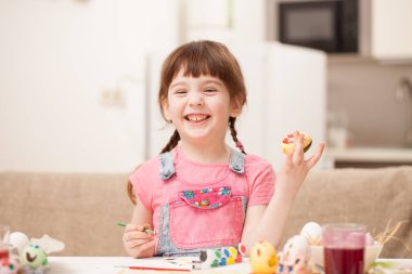 Kız bir şekilde dekore edilmiş bir yumurta ve gülümsüyor tutar