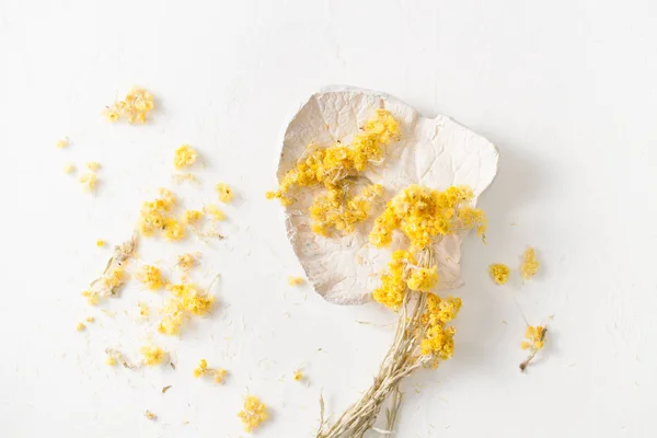 L'herbe séchée Helichrysum sur une table blanche — Photo