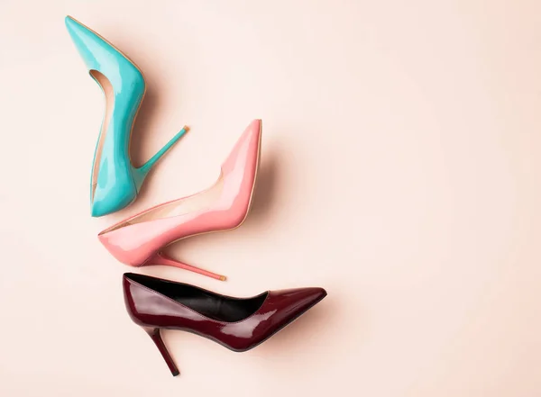 Uppsättning färgade kvinnors skor på rosa bakgrund — Stockfoto