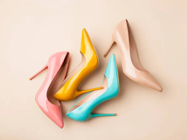 Conjunto de sapatos femininos coloridos em fundo bege — Fotografia de Stock