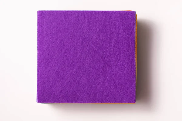 Flatlay a stack of felt pieces with a purple top on a white background — Stock fotografie