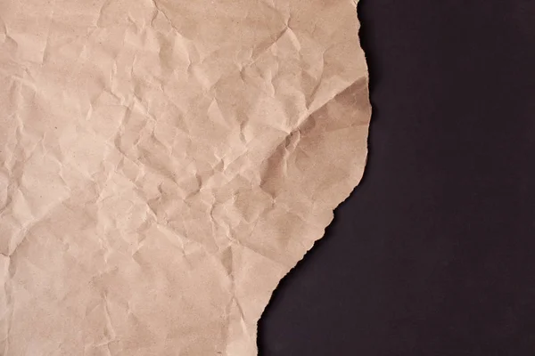Crumpled recycled paper with a torn edge on a black background — 스톡 사진