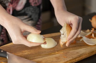 Aşçı odun kesme tahtasıyla soğan doğruyor. Yakın çekim..