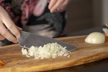 Aşçı odun kesme tahtasıyla soğan doğruyor. Yakın çekim..