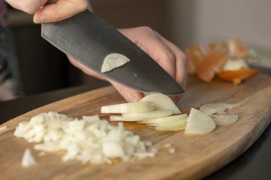 Aşçı odun kesme tahtasıyla soğan doğruyor. Yakın çekim..