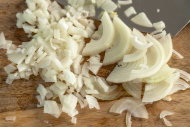 Aşçı odun kesme tahtasıyla soğan doğruyor. Yakın çekim..