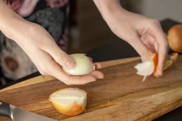 The cook cutting and dice onion on a wooden chopping board. Closeup.