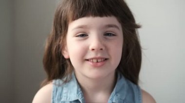 6-7 yaşlarında bir kız kameraya bakıp gülüyor. Kapat..