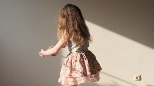 7歳の女の子ありますスピニングとともに彼女のお気に入りのおもちゃでAサニールームに自宅 — ストック動画