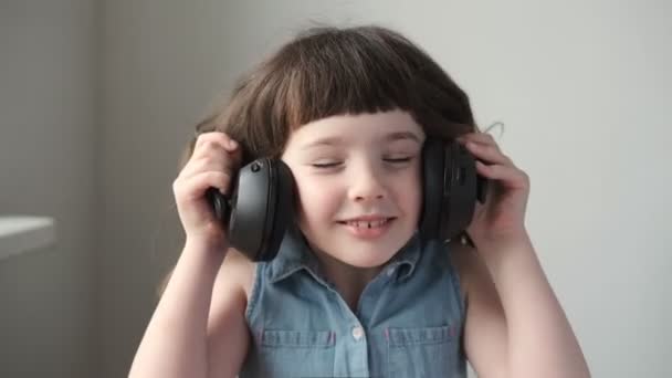 Uma Menina Anos Coloca Grandes Fones Ouvido Sem Fio Ouve — Vídeo de Stock