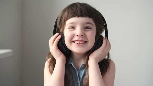 Una Niña Años Con Auriculares Inalámbricos Grandes Escucha Ríe Cerca — Vídeos de Stock