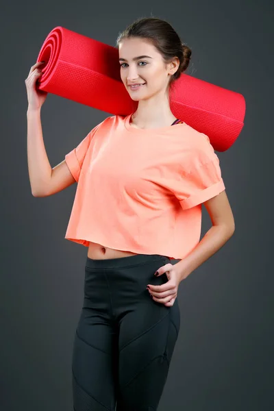 Athletisches Mädchen mit roter Sportmatte — Stockfoto