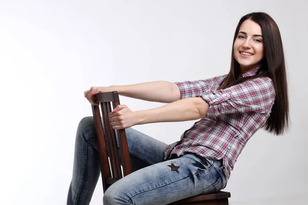 happy woman in shirt on a chair