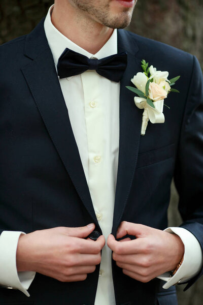 Posed groom with button hole.Wedding details, beautiful boutonniere, mens details