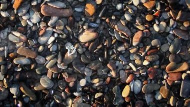 Aşağı renkli taşlar hakkında 4 k döngü bir görünümü tam tepeden aşağıya renkli taşlara buzlu düşme ve bir su birikintisi bir döngü içinde şekillendirme yağmur şekil ile yağmur.