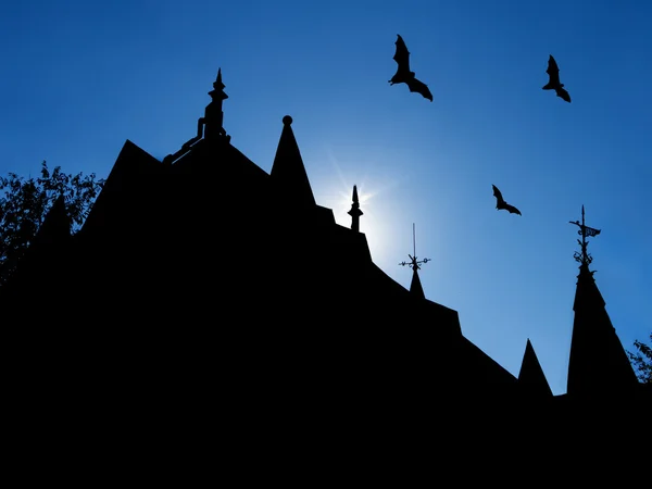 Halloween background with silhouettes of castle roofs with  weathervanes and three flying bats — Stock Photo, Image