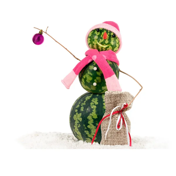 Καρπούζι Χριστούγεννα χιονάνθρωπος σε ροζ καπέλο και κασκόλ στο χιόνι με Χριστουγεννιάτικες μπάλες και δώρα λινό τσουβάλι. Διακοπών ιδέα για Χριστούγεννα και νέο έτος. — Φωτογραφία Αρχείου