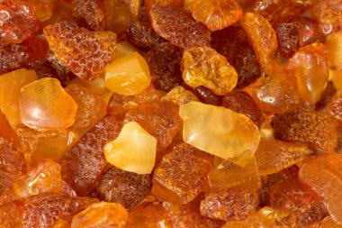 Yakın plan kehribar taşları düz bir yüzeyde yatar..