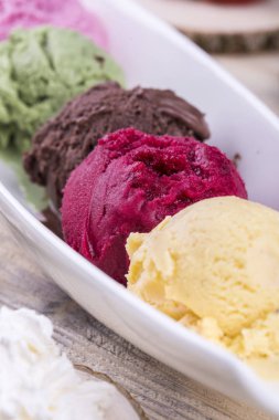 Hafif ahşap arka plan üzerinde beyaz eşya üzerinde çok renkli topları ile blackcurrant dondurma