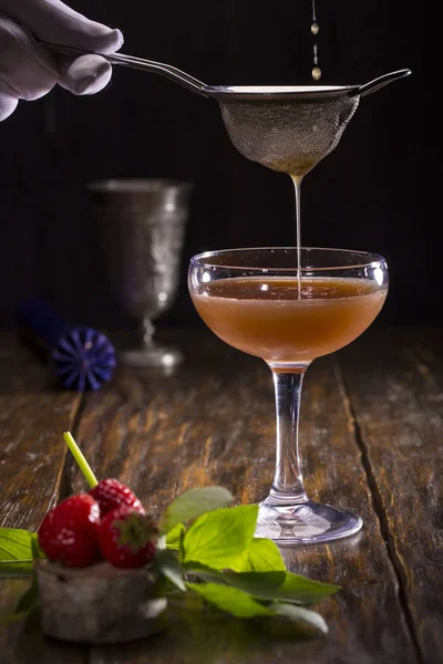 Jordgubbe och mynta cocktail, på en trä bakgrund, filtreras genom ett såll — Stockfoto