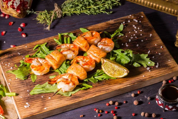 Som balığı şiş kebap ve karides, roka ve kireç yaprakları ile servis edilir