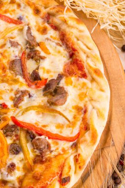 Parça pizza Dana eti, kırmızı biber ve rendelenmiş peynir ile