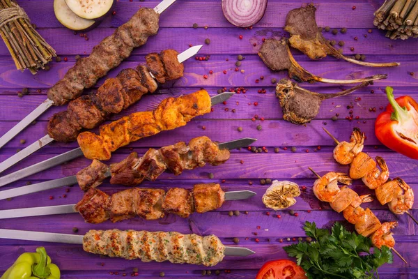 Şiş kebap, kızarmış patates, soğan, kırmızı biber, maydanoz ve baharat salatası, dilim domates ve sosu bir garnitür ile servis edilir