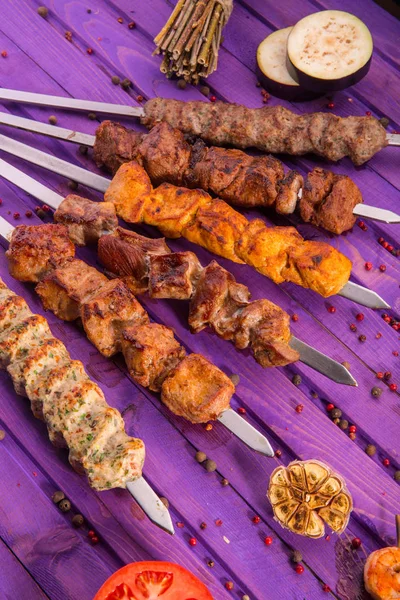 A shish kebab on skewers with fried vegetables and spices — Stock Photo, Image