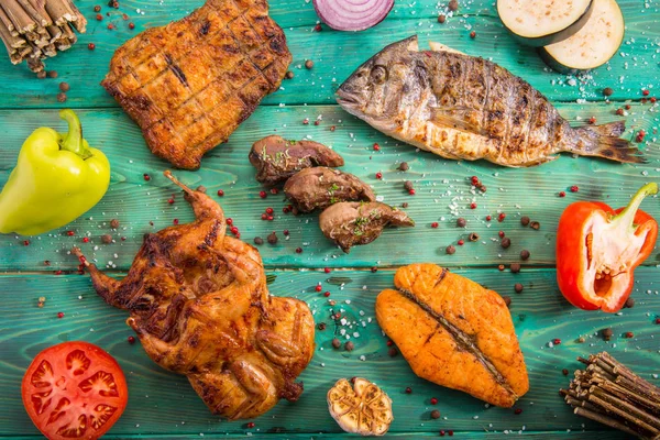 Meat allsorts from different types of meat and fish with the vegetables and spices fried on coals — Stock Photo, Image