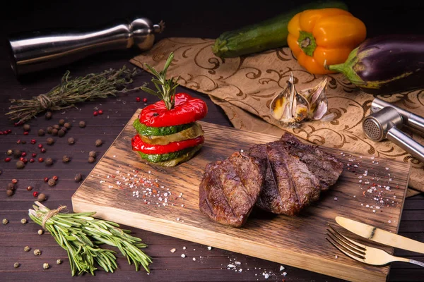 Um medalhão de lombo de vaca suculento com uma berinjela, um tutano vegetal e páprica, preparado em uma grelha — Fotografia de Stock